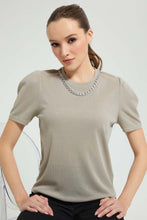 تنزيل الصورة على معرض الصور، بلوزة باللون الأخضر مزينة بسلسال وأكمام منفوشة